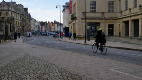 Panning-Shot-of-Cyclists-Riding-Down-Old-Street-