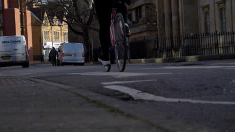 Low-Angle-Shot-of-Cyclist-Riding-Down-a-Street