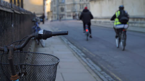 Handheld-Close-Up-Shot-of-Bicycle-Handlebars-as-Cyclists-Ride-Past
