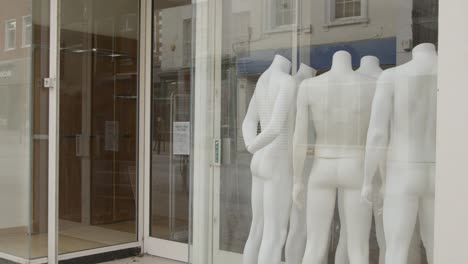 Tracking-Shot-Past-Shop-Window-Full-of-Disused-Mannequins-