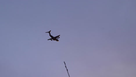 Handheld-Shot-Looking-Up-at-Military-Aircraft-Flying-at-Sunset