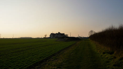 Tracking-Shot-Along-Field-Footpath-Leading-to-Farmhouse-