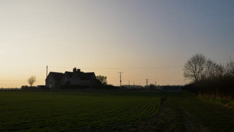 Tilting-Shot-Looking-Up-from-Puddle-to-Reveal-Farmhouse-at-Sunset