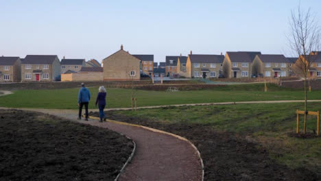 Tracking-Shot-Following-Couple-Walking-Along-Footpath-Leading-to-New-Housing-Area
