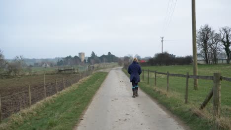 Tracking-Shot-Following-Woman-Walking-Down-Countryside-Road