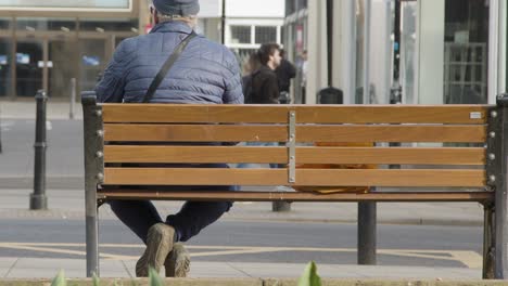 Medium-Shot-of-Person-Sitting-On-Street-Bench