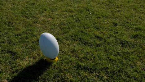 High-Angle-Shot-Rotating-Around-Rugby-Ball-On-Tee