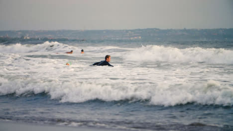 Handheld-Long-Shot-of-Surfer-Swimming-Out-to-Ocean