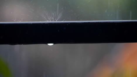 Close-Up-Shot-of-Rain-Falling-On-Metal-Fence-Pole