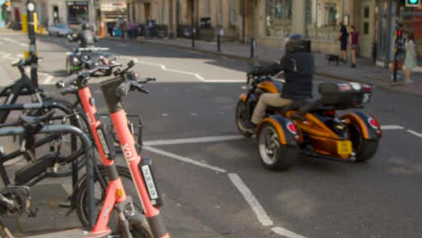 Close-Up-Shot-of-Electric-Scooters-as-Traffic-Goes-Past