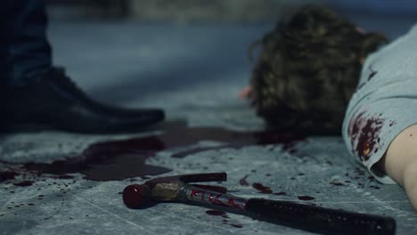 Sliding-Close-Up-Shot-of-Bloody-Hammer-Dropping-Next-to-a-Body