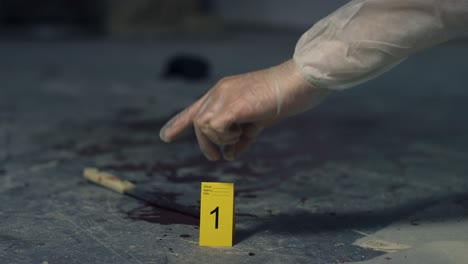 Sliding-Close-Up-of-Forensic-Placing-Evidence-Tag-Next-to-Bloody-Knife