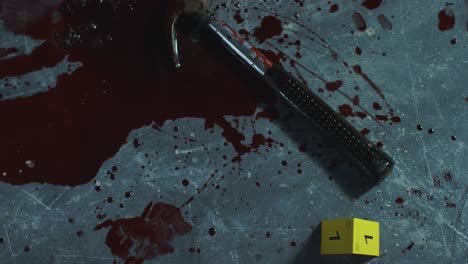 High-Angle-Shot-Looking-Down-at-a-Bloody-Hammer-at-Crime-Scene