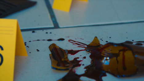 Sliding-Extreme-Close-Up-Shot-of-Evidence-Tags-On-Floor-Next-to-Bloody-Broken-Bottle