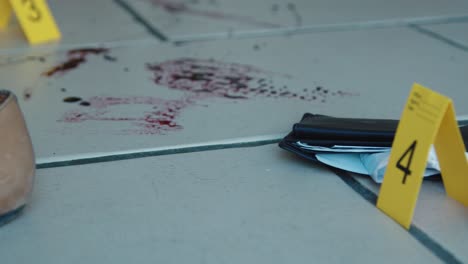 Sliding-Close-Up-Shot-of-Evidence-Tags-On-Floor-Next-to-Bloody-Broken-Bottle
