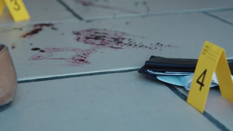 Sliding-Close-Up-Shot-of-Evidence-Tags-On-Floor-Next-to-a-Bloody-Broken-Bottle