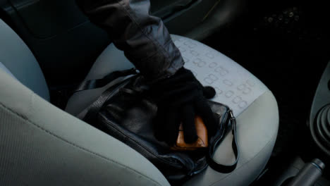 Panning-High-Angle-Shot-of-Handbag-and-Purse-Being-Stolen-from-a-Car-Seat