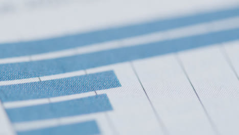 Sliding-Extreme-Close-Up-Shot-of-Newspaper-Page-with-Stock-Market-Chart