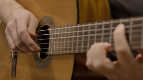 Panning-Shot-of-Musicians-Hands-Playing-Acoustic-Guitar