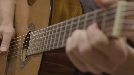 Close-Up-Shot-of-Musicians-Hand-On-Fret-Board-of-Acoustic-Guitar