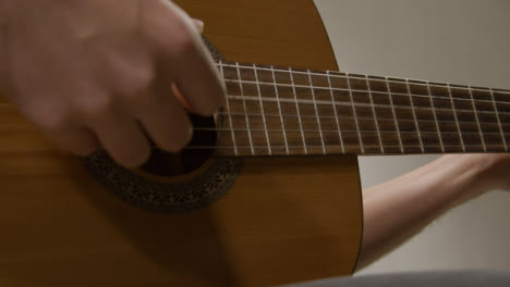 Tracking-Shot-Approaching-a-Musicians-Hand-Plucking-Acoustic-Guitar-Strings