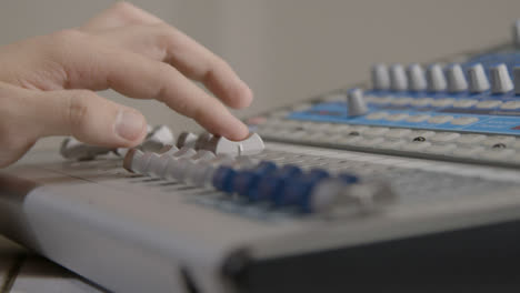 Tracking-Shot-of-Sound-Mixers-Hand-Adjusting-Faders-