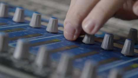 Close-Up-Shot-Following-Sound-Mixers-Hand-Adjusting-Knobs-On-Sound-Board