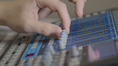 Close-Up-Shot-of-Sound-Mixers-Hand-Adjusting-Sound-Board-Knobs