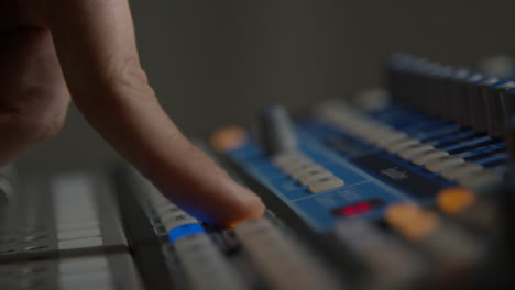 Close-Up-Shot-of-Sound-Mixers-Hand-Pressing-Button-and-Adjusting-Sound-Board-Knobs