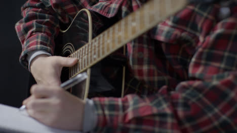 Medium-Shot-of-Musician-Holding-Acoustic-Guitar-and-Writing-