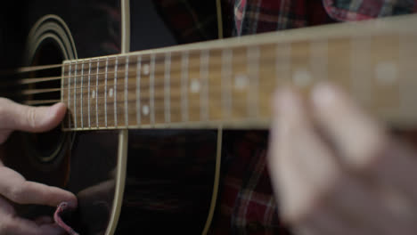Sliding-Close-Up-Shot-of-Musician-Strumming-Guitar-Strings