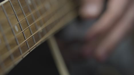 Sliding-Extreme-Close-Up-Shot-of-Musicians-Hands-Playing-Acoustic-Guitar