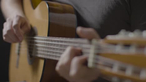 Pull-Focus-Shot-from-Acoustic-Guitar-Fret-Board-to-Body-as-Musician-Plays