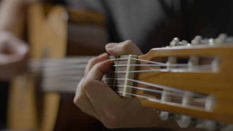 Sliding-Close-Up-Shot-of-Musicians-Hand-On-Acoustic-Guitar-Fret-Board