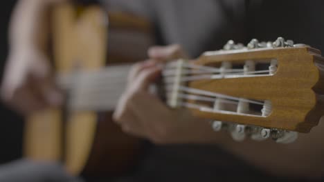 Sliding-Close-Up-Shot-of-Musicians-Hand-On-Acoustic-Guitar-Fret-Board