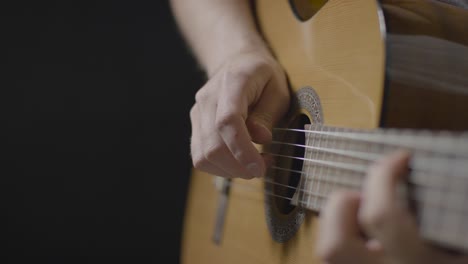 Close-Up-Shot-of-Musicians-Hands-Plucking-Strings-On-Acoustic-Guitar