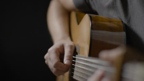 Sliding-Close-Up-Shot-Approaching-Acoustic-Guitar-Body-as-Musician-Plays-