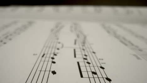 Tracking-Shot-Over-Bars-On-Music-Sheet-Book-Page-
