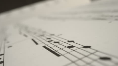 Tracking-Shot-Over-Bars-On-a-Music-Sheet-Book-Page-