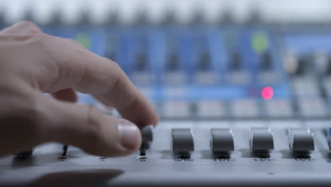 Close-Up-Shot-of-Audio-Mixers-Hand-Adjusting-Faders-On-Audio-Mixing-Board