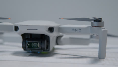 Close-Up-Shot-of-DJI-Mini-2-Drone-Sitting-On-Table-