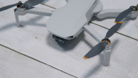 High-Angle-Shot-of-DJI-Mini-2-Drone-Sitting-On-a-Table