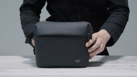 Tracking-Shot-Approaching-Person-Placing-DJI-Bag-On-Table