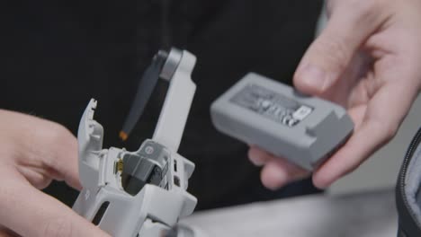 Close-Up-Shot-of-Person-Inserting-Battery-into-DJI-Mini-2