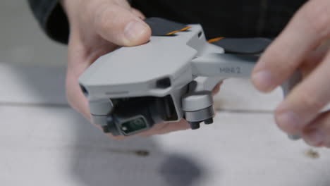 Close-Up-Shot-of-Person-Folding-Out-Arms-On-DJI-Mini-2