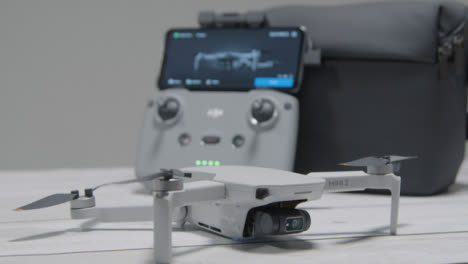 Ziehen-Sie-Den-Fokus-Von-Der-DJI-Mini-2-Drohne-Auf-Den-Controller,-Der-Auf-Dem-Tisch-Sitzt