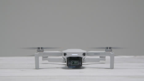 Mittlere-Aufnahme-Der-DJI-Mini-2-Drohne,-Die-Vom-Tisch-Abhebt