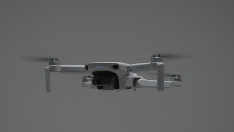 Medium-Shot-of-DJI-Mini-2-Drone-Rotating-In-Air
