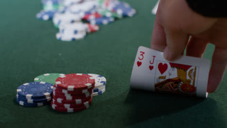 Nahaufnahme-Eines-Spielers,-Der-Seine-Pokerhand-überprüft,-Bevor-Er-All-In-Geht-Going