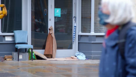 Long-Shot-of-Homeless-Persons-Belongings-In-Disused-Shop-Entrance